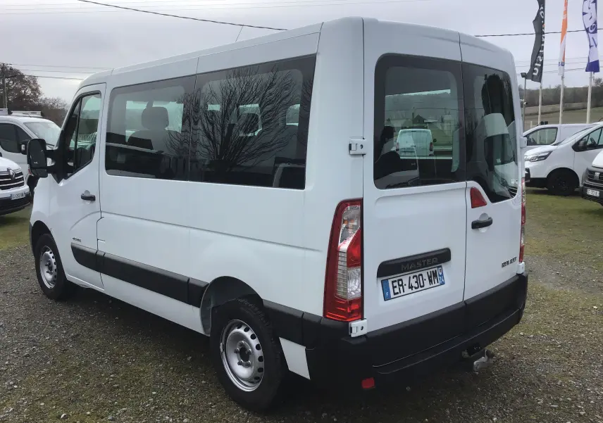 Vue 3/4 arrière droite d'un Renault Master Combi III blanc, version L1H1 9 places, avec vitres latérales teintées.