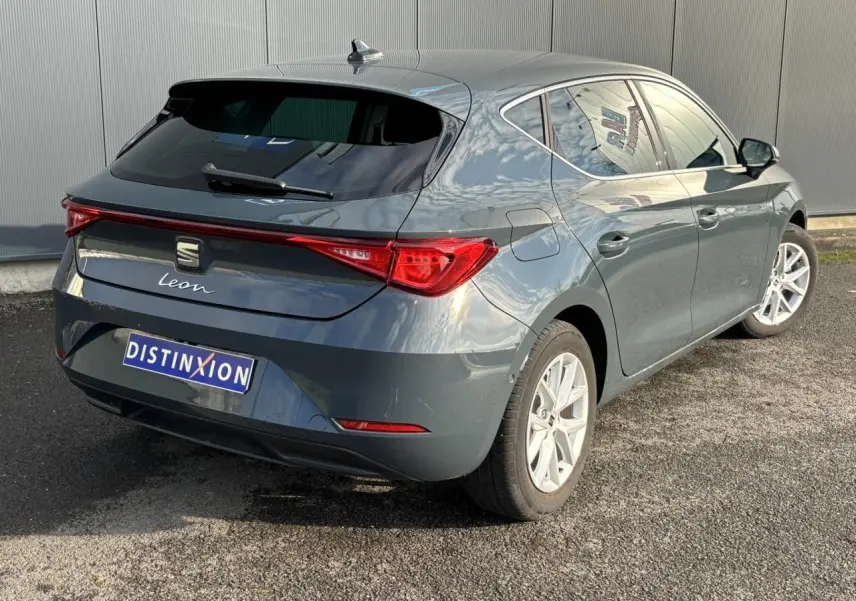 Vue 3/4 arrière droite d'une SEAT Leon 2.0 TDI 115 Style bleu Fjord avec jantes alliage 16 pouces et vitres surteintées.