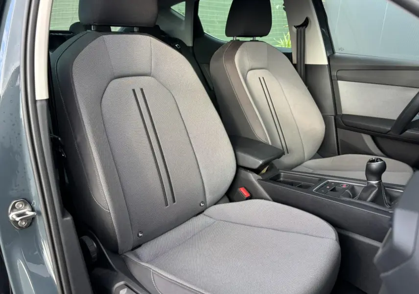 Vue intérieure côté conducteur du SEAT Leon 2.0 TDI 115 Style 2025, sièges gris et levier de vitesses manuel visible.