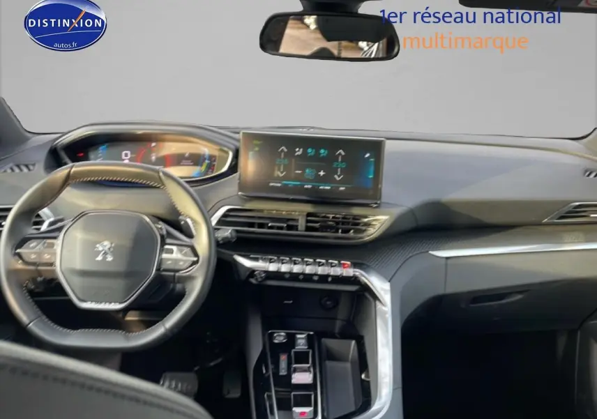 Vue intérieure avant du tableau de bord et volant cuir du Peugeot 3008 2024 avec écran tactile et inserts carbone.