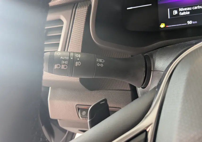 Gros plan sur la commande des feux et clignotants à gauche du volant dans le Renault Trafic Cabine Approfondie gris comète 2025.