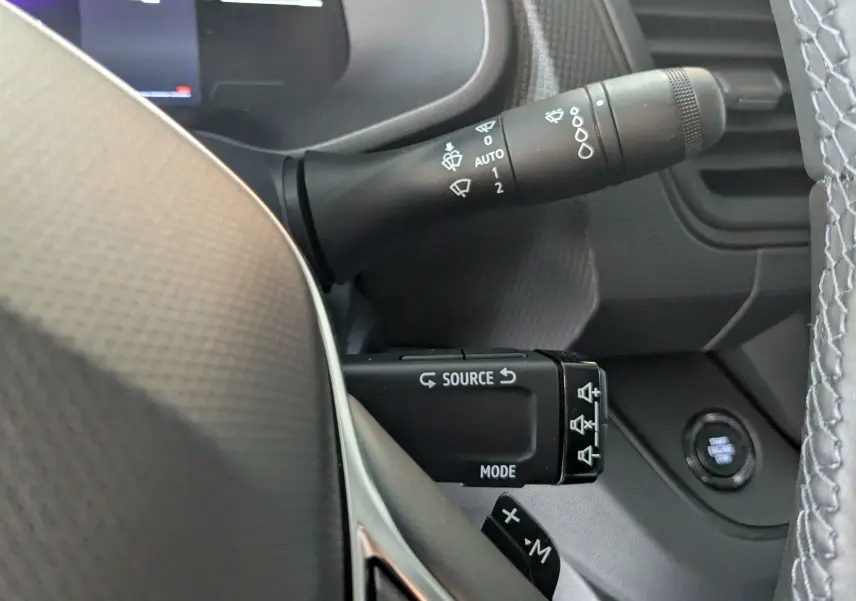 Gros plan sur la commande d’essuie-glace et boutons multifonctions du volant du Renault Trafic cabine approfondie gris comète.