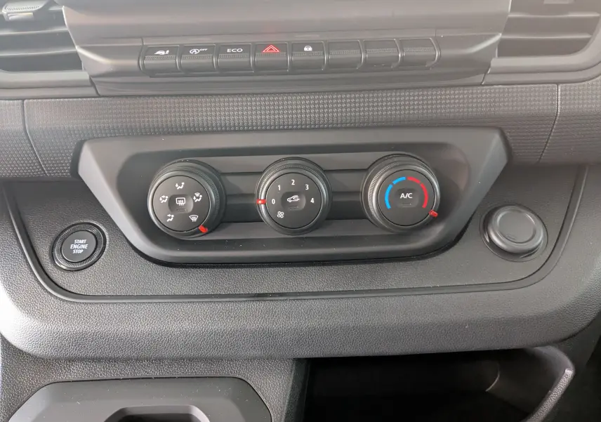 Détail du tableau de bord du Renault Trafic Cabine Approfondie 2025, montrant les commandes de climatisation et le bouton Start Engine Stop.