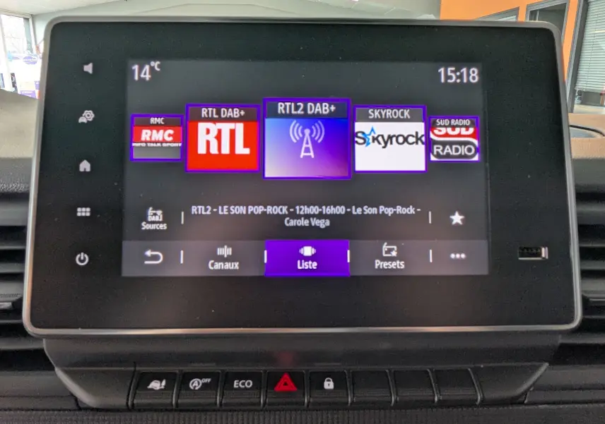 Écran tactile central du Renault Trafic cabine approfondie 2025 affichant les stations radio numériques, avec boutons de commande en dessous.