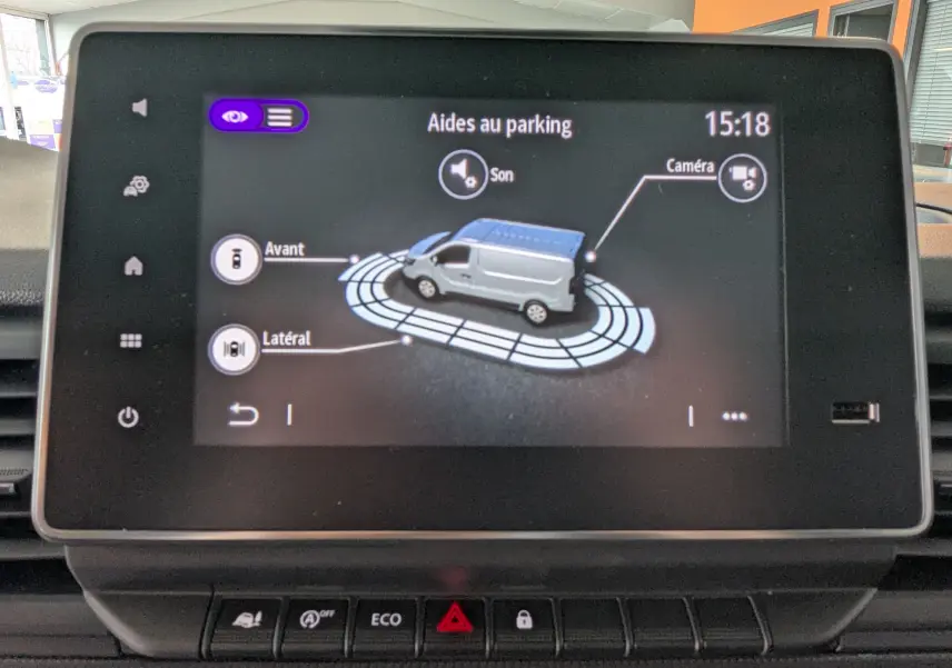 Écran tactile intérieur montrant l’aide au parking du Renault Trafic gris comète en vue 3D latérale.