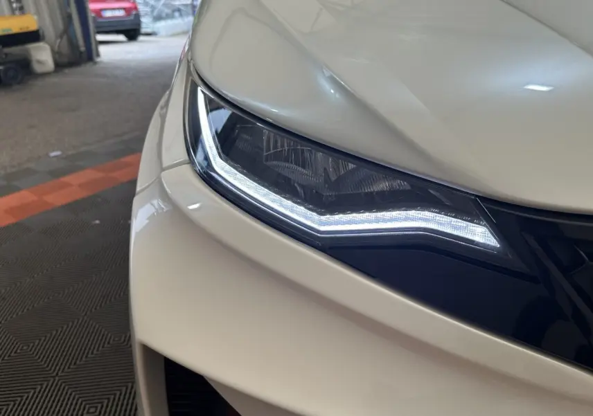 Gros plan sur le phare avant gauche blanc de l'AIXAM AMBITION 0.5 CROSSOVER PREMIUM 2026 avec éclairage LED distinctif.