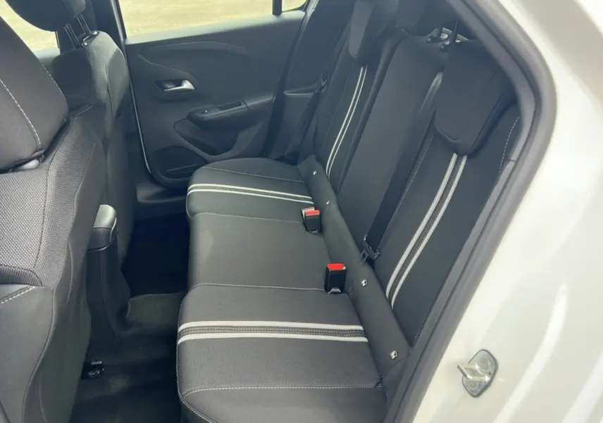 Vue intérieure côté arrière droit de la banquette noire avec surpiqûres blanches dans une Opel Corsa blanc kontur.