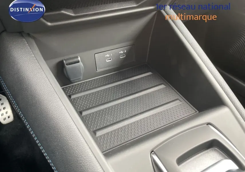 Gros plan sur la console centrale avec prise USB double et surface antidérapante du Renault Symbioz gris Cassiopée.