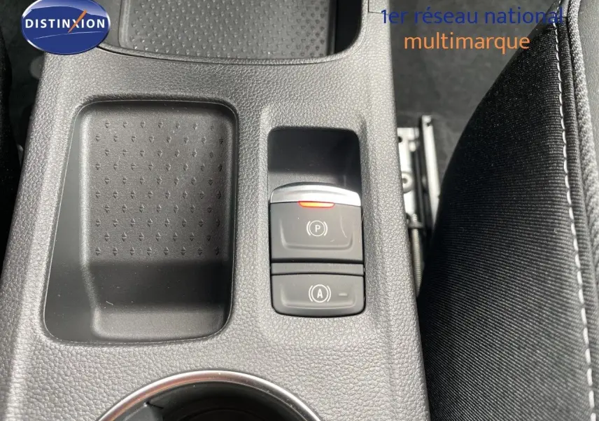 Gros plan sur la console centrale noire avec boutons de frein à main et arrêt automatique de la Renault Symbioz gris cassiopée.