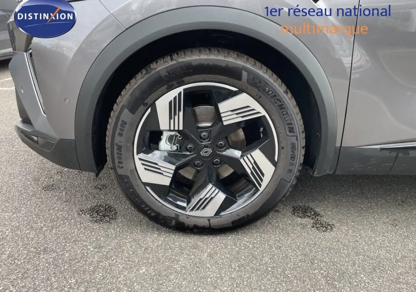Gros plan sur la roue avant gauche du Renault Symbioz gris cassiopée métal, mettant en valeur la jante noire et argentée au design moderne.