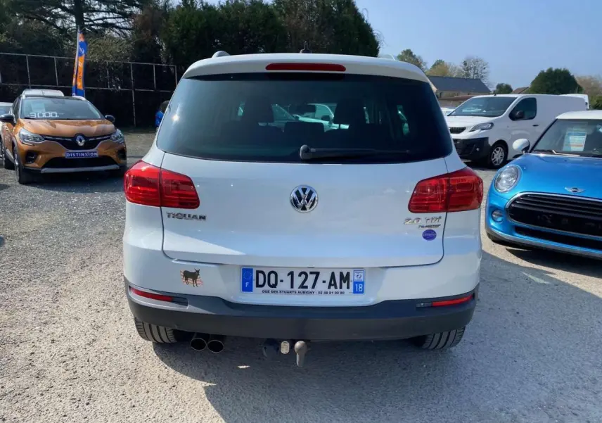 Vue arrière d'un Volkswagen Tiguan blanc de 2014 avec attelage et double sortie d'échappement visible.