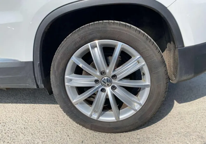 Gros plan sur la jante en alliage 18 pouces côté arrière droit d'un Volkswagen Tiguan blanc de 2014.