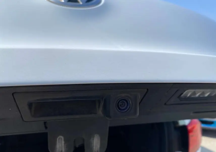 Gros plan sur la caméra de recul intégrée au hayon arrière blanc d’un Volkswagen Tiguan 2014.