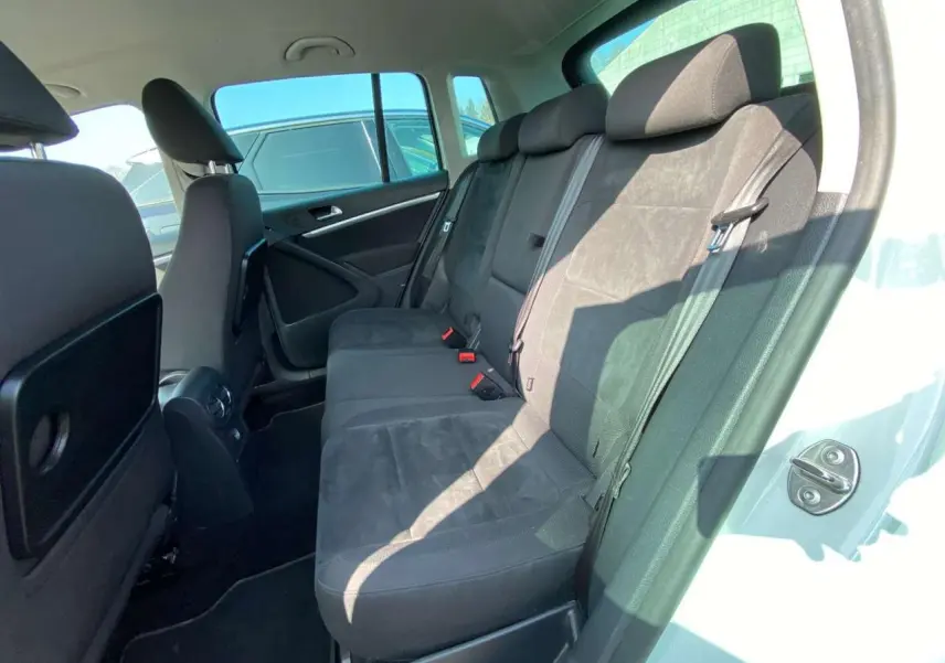 Vue intérieure côté droit montrant les sièges arrière noirs du Volkswagen Tiguan blanc de 2014.