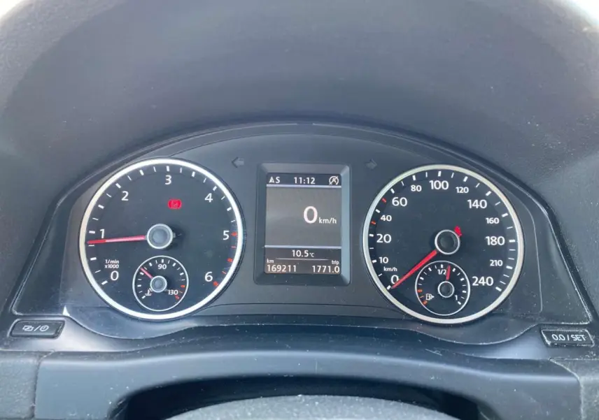 Vue rapprochée du tableau de bord du Volkswagen Tiguan blanc, affichant compte-tours, vitesse et écran multifonction.