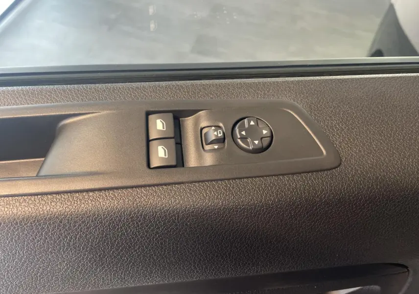 Commande des vitres et réglage des rétroviseurs sur la porte intérieure côté conducteur d'un Opel Vivaro noir carbone 2025.