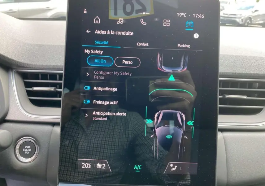 Écran tactile central affichant les aides à la conduite dans l'habitacle du Renault Captur gris Cassiopée avec toit noir.
