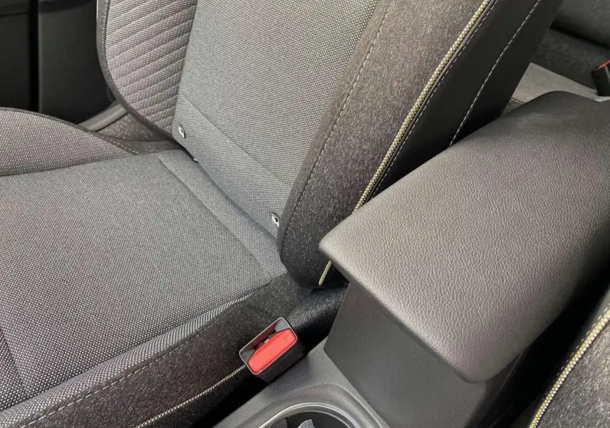 Gros plan sur la console centrale et siège avant gris du Renault Captur Techno 2025 avec surpiqûres contrastées.