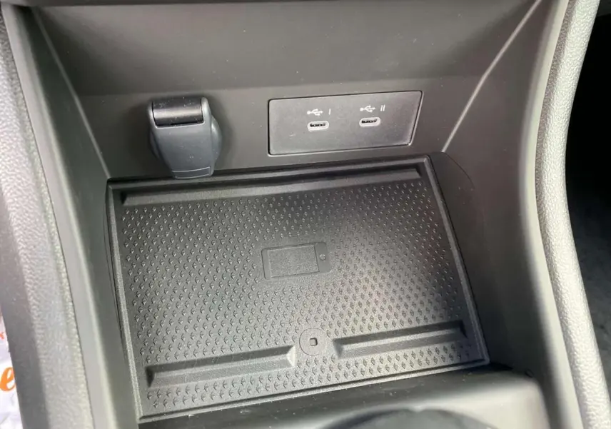 Espace de rangement avec chargeur sans fil et ports USB dans le Renault Captur Techno 2025, intérieur noir.