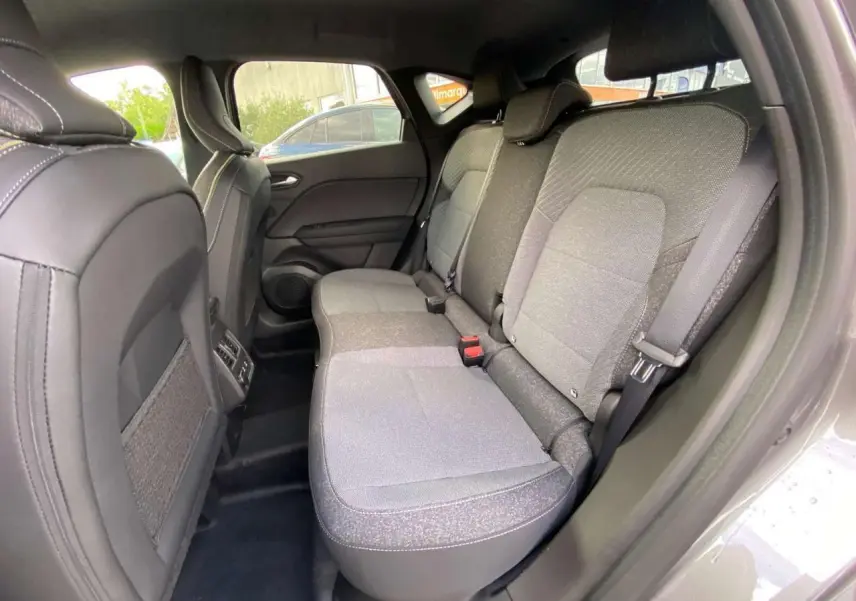 Vue intérieure sur la banquette arrière grise du Renault Captur 2025, avec ceintures et appuis-tête visibles.