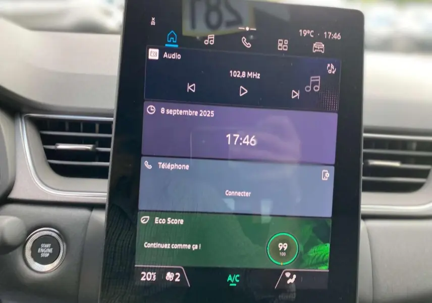 Écran tactile central du tableau de bord du Renault Captur 2025 affichant radio, téléphone et score Eco.