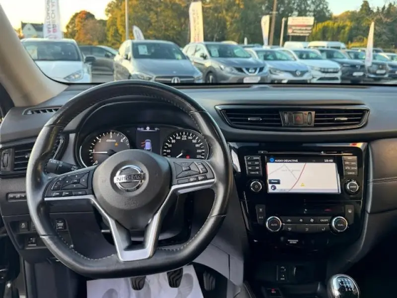 Vue intérieure du tableau de bord et volant cuir multifonction du Nissan X-Trail noir intense, avec écran tactile et commandes intégrées.