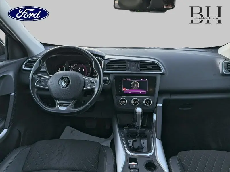 Vue intérieure frontale du tableau de bord noir étoilé du Renault Kadjar 1.3 TCe 140ch avec écran tactile et volant multifonction.
