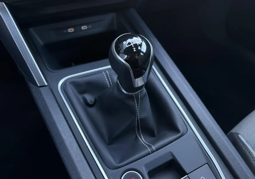 Gros plan sur le levier de vitesses manuel noir de la SEAT LEON ST 2.0 TDI 115 Style, intérieur moderne et soigné.