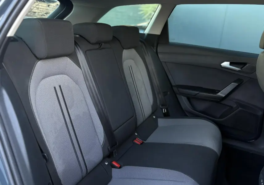 Vue latérale droite des sièges arrière bi-ton gris et noir du SEAT LEON ST 2.0 TDI 115 Style 2025 avec ceinture de sécurité visible.