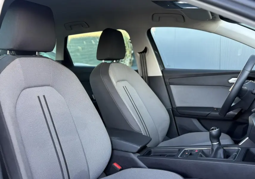 Vue intérieure côté droit sur les sièges gris et la console centrale avec levier de vitesse manuelle de la SEAT LEON ST 2025.