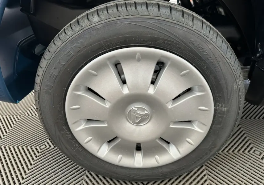 Gros plan sur la roue avant droite de l'AIXAM AMBITION 0.5 CITY PACK bleu, avec jante argentée et logo central.