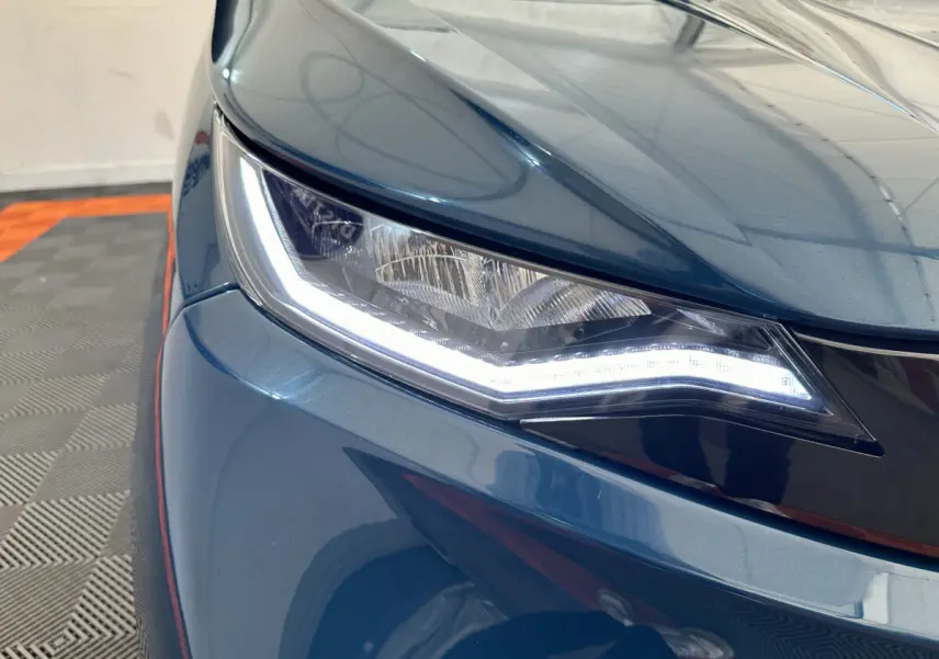 Gros plan sur le phare avant gauche d’une Aixam Ambition 0.5 City Pack bleu 2026 avec éclairage LED distinctif.