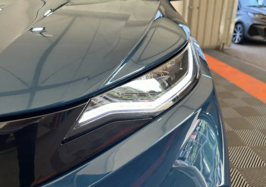 Gros plan sur le phare avant droit bleu de l'AIXAM AMBITION 0.5 CITY PACK 2026 avec éclairage LED distinctif.