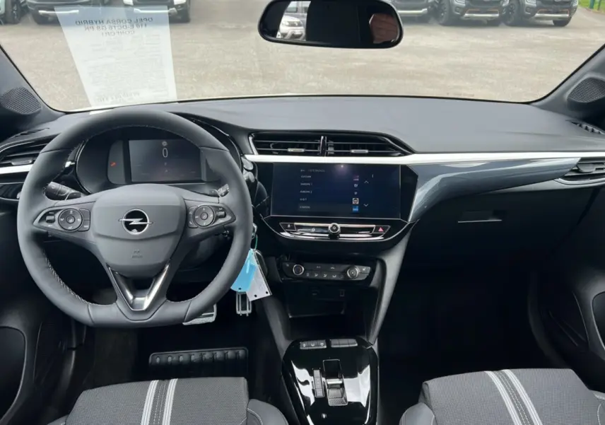 Vue intérieure avant de l’Opel Corsa Hybrid blanc Kontur, volant cuir multifonctions et écran tactile 10 pouces au centre.