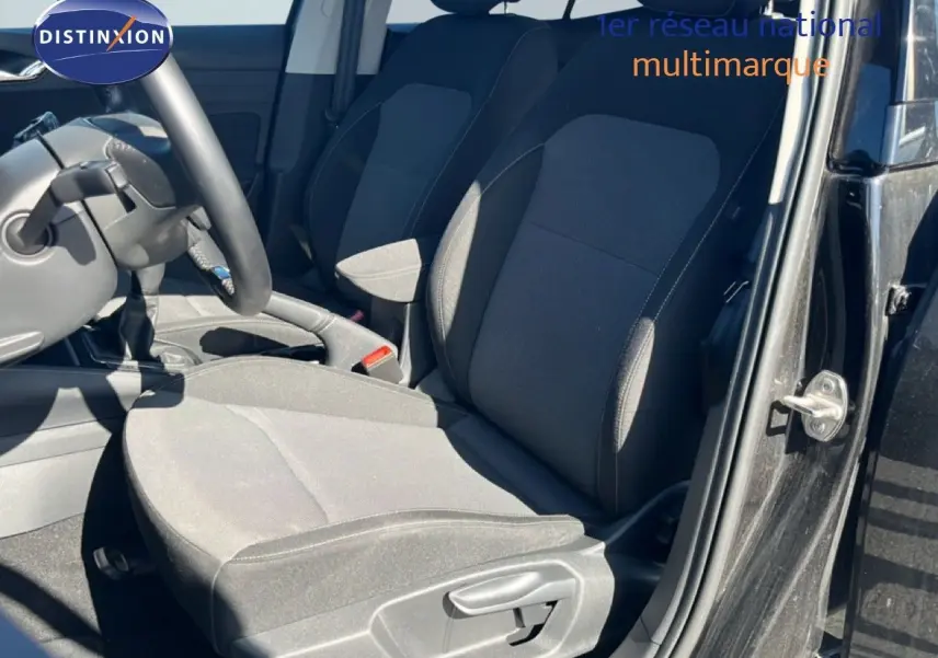 Vue intérieure côté conducteur de la Skoda Fabia 2025 noir magique métal, sièges tissu gris foncé et volant multifonctions.