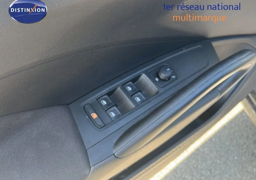 Détail de la commande des vitres électriques sur la portière avant gauche d'une Skoda Fabia noire.