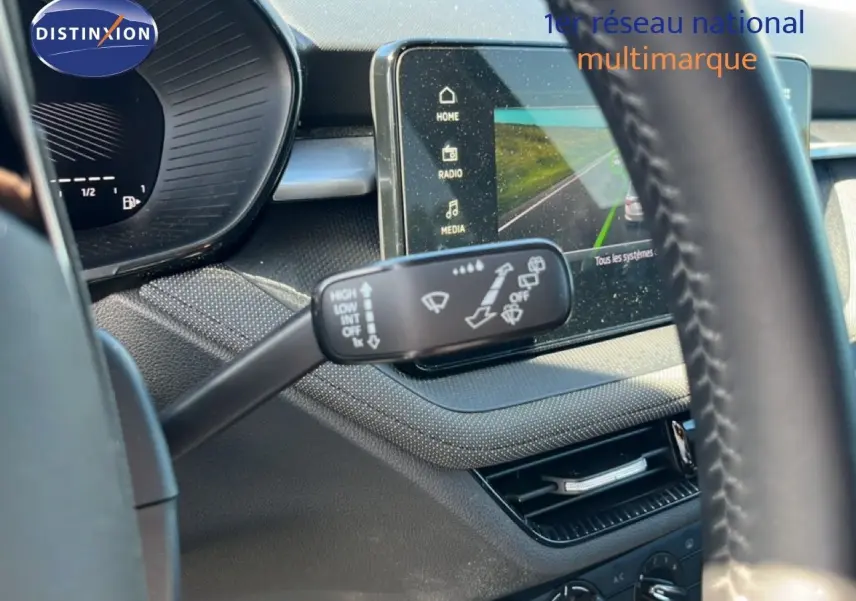 Gros plan sur la commande d’essuie-glace et l’écran tactile du tableau de bord intérieur d’une Skoda Fabia noire.