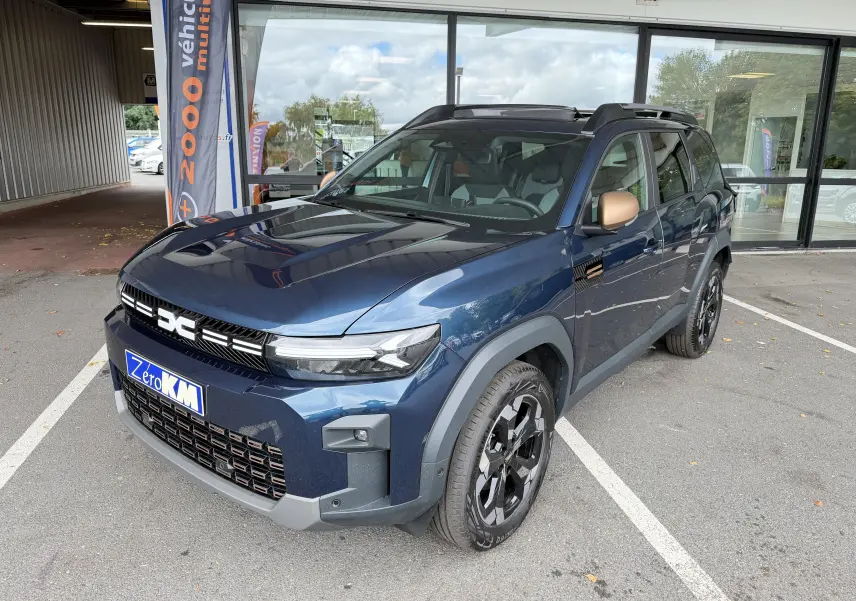 Vue 3/4 avant droite du Dacia Bigster Hybrid 155 Extreme bleu indigo avec jantes alliage noires et rétroviseurs bronze.