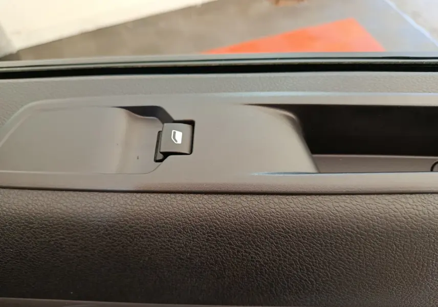 Détail de la commande de lève-vitre sur la porte intérieure d’un Peugeot Expert Fourgon noir, vue rapprochée.