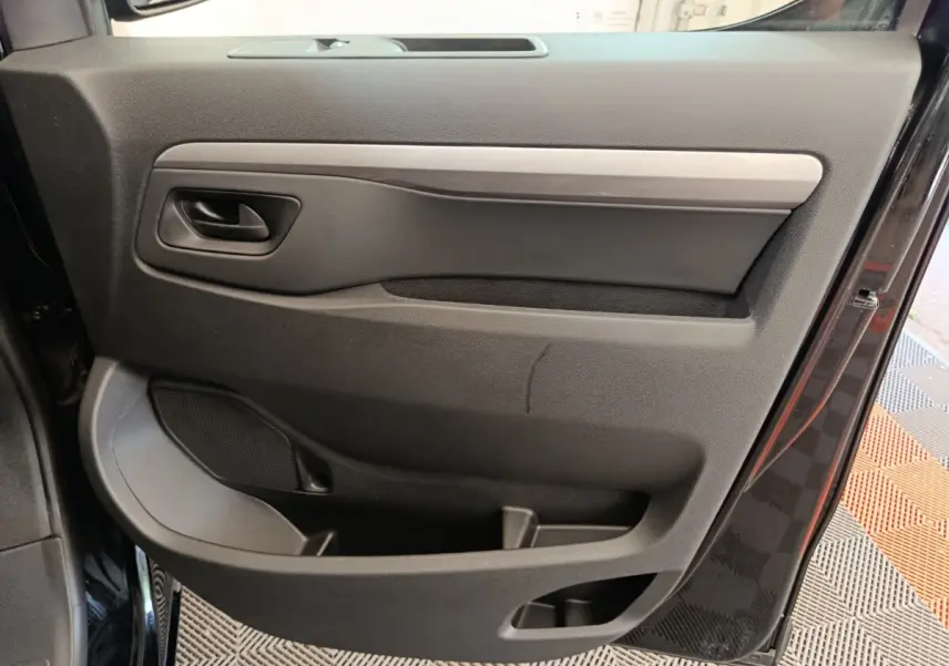 Vue rapprochée de la porte côté gauche noire du Peugeot Expert Fourgon XL Diesel 2026 avec poignée intégrée et rangement.