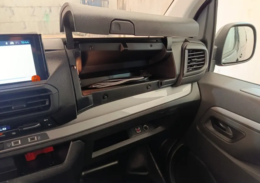 Intérieur du Peugeot Expert Fourgon XL Diesel 2026, vue côté passager avec boîte à gants ouverte et tableau de bord noir et gris.