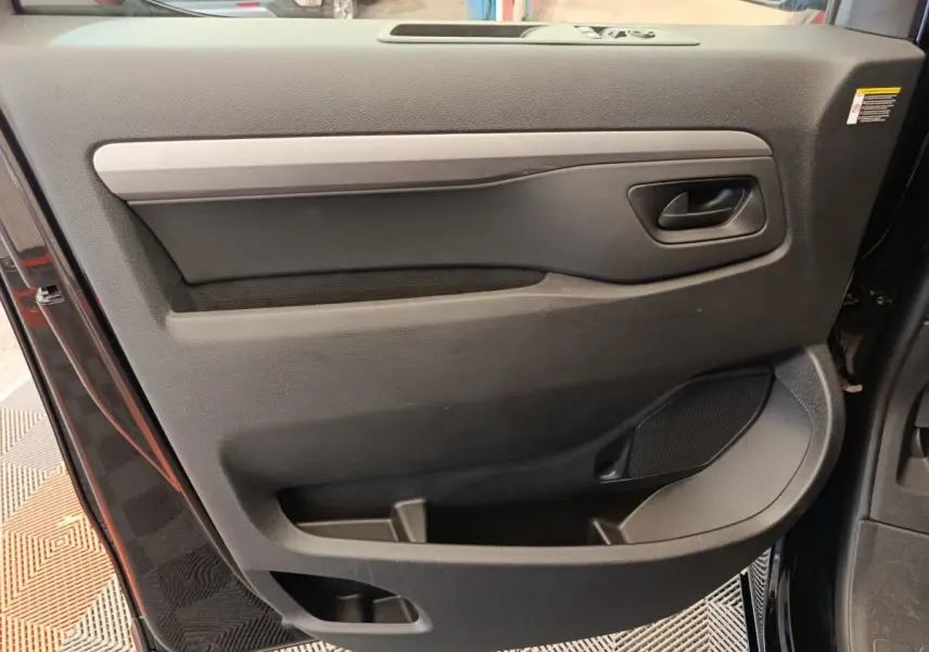 Vue intérieure de la porte avant droite noire du Peugeot Expert Fourgon XL Diesel 2026 avec poignée et rangements intégrés.