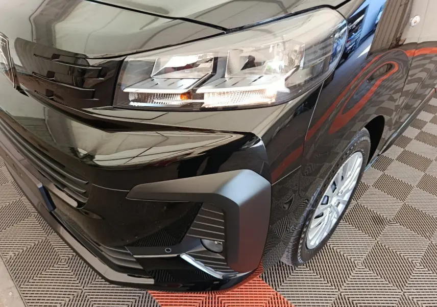 Gros plan sur l’avant droit du Peugeot Expert Fourgon XL noir, mettant en valeur le phare et la calandre moderne.