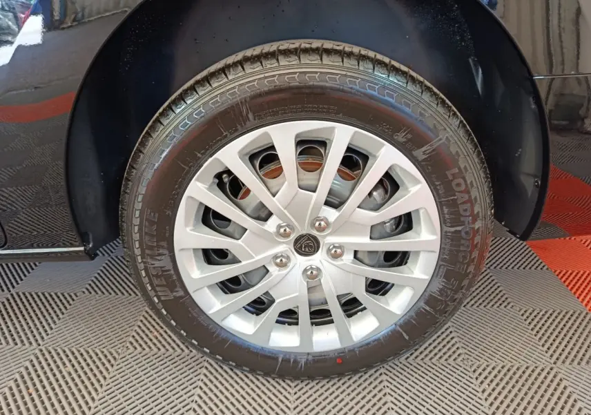 Gros plan sur la roue avant droite du Peugeot Expert Fourgon noir, avec jante argentée et logo Peugeot central.