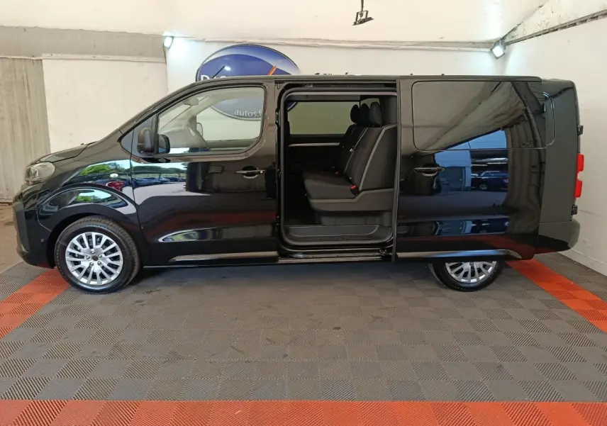Vue latérale gauche d’un Peugeot Expert Fourgon XL noir avec porte coulissante ouverte révélant la banquette arrière trois places.