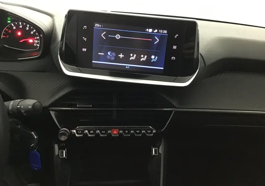 Vue intérieure centrée sur l'écran tactile et la console de la Peugeot 208 noire, version 1.2 PureTech 100 Style GPS 2022.