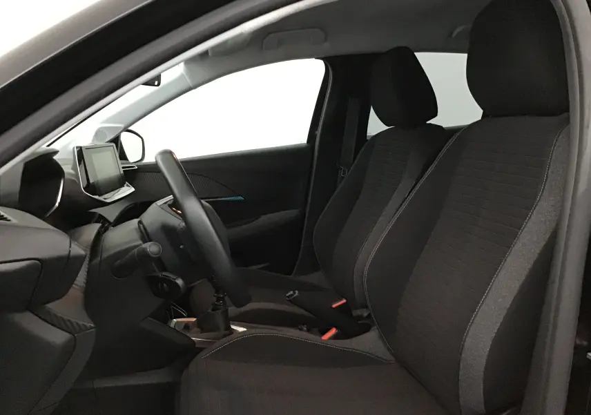 Intérieur avant droit de la Peugeot 208 noire 2022, montrant sièges tissu noir et tableau de bord avec écran tactile.