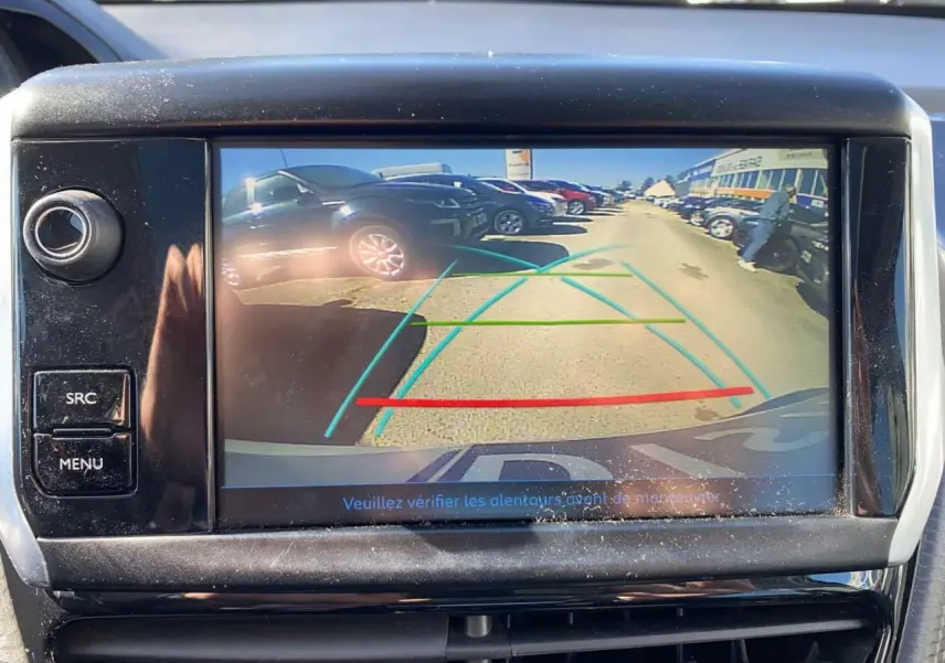 Vue de la caméra de recul du Peugeot 2008 2019 montrant une rangée de voitures sur un parking en arrière-plan.