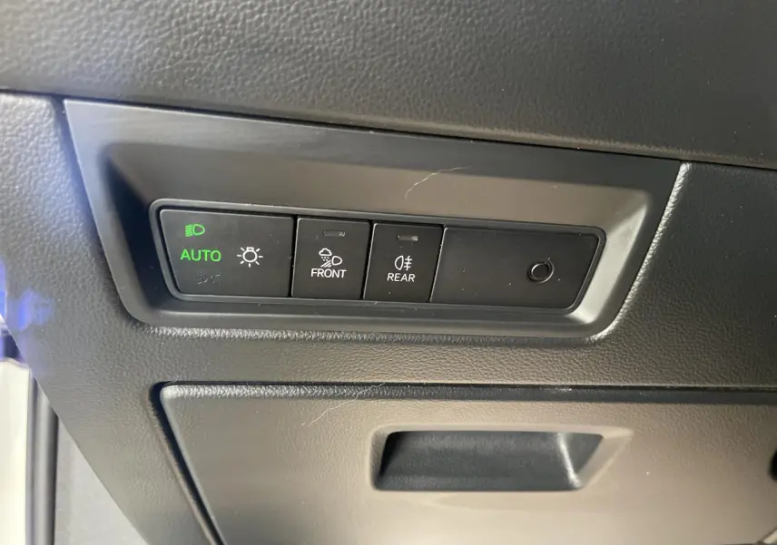 Panneau de commandes des feux avec mode automatique allumé dans un Volkswagen Touareg blanc, vue intérieure.