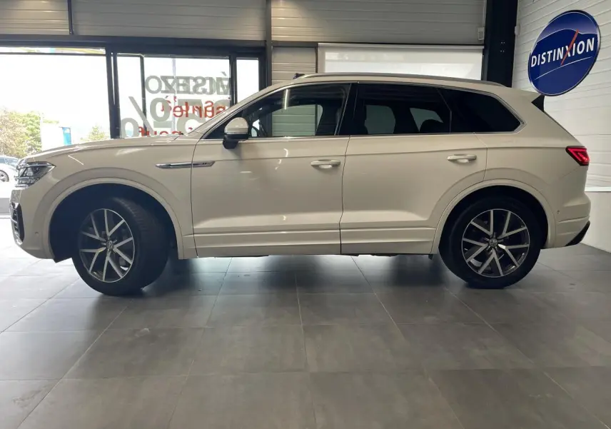 Profil côté gauche d'un Volkswagen Touareg blanc 2019 avec jantes alliage 20 pouces et vitres teintées.